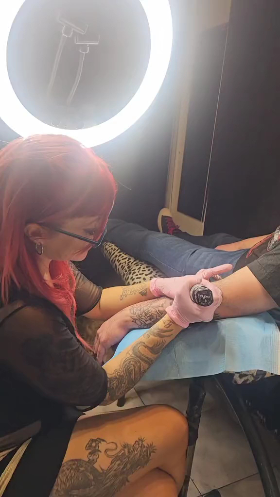 Artista de Grooving Tattoo Studio tatuando a un cliente en el local